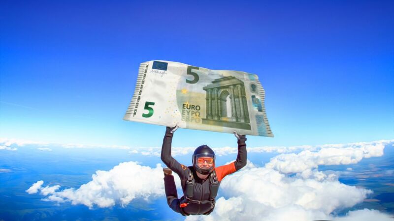 Un homme tient un billet de 5 euros