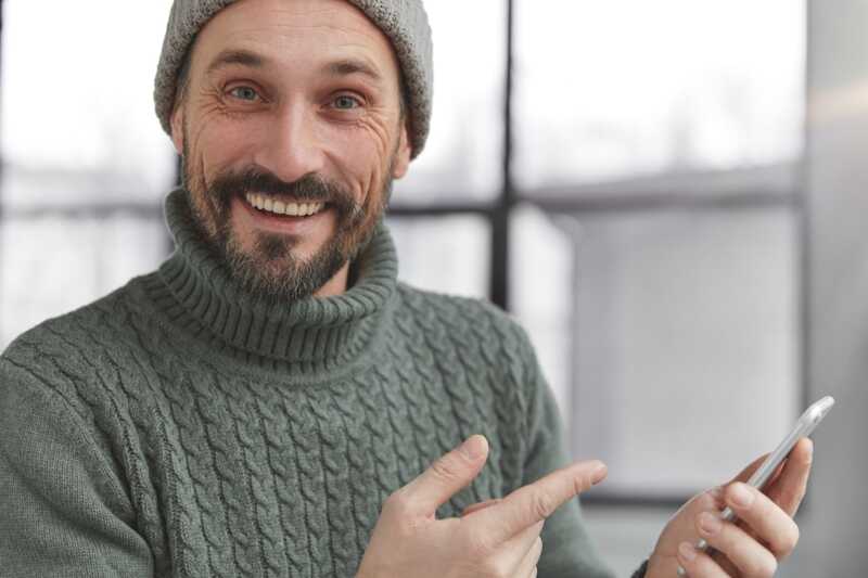 homme content d'utiliser Cyberghost sur son smartphone