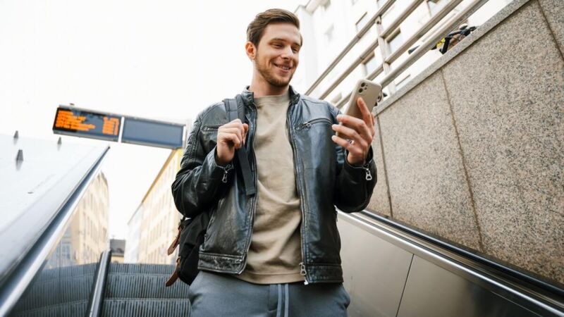 Un homme regarde son téléphone dans un escalator