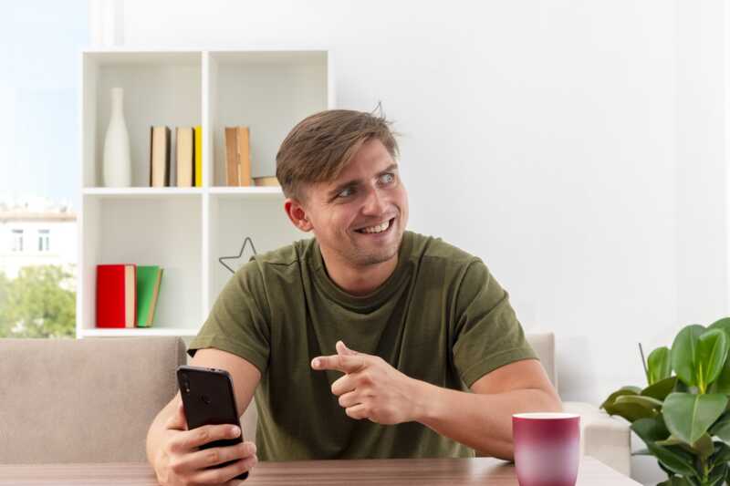 homme content devant son smartphone