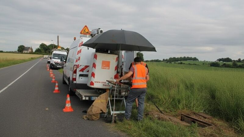 Des techniciens Orange réparent une panne de fibre optique le long d'une route