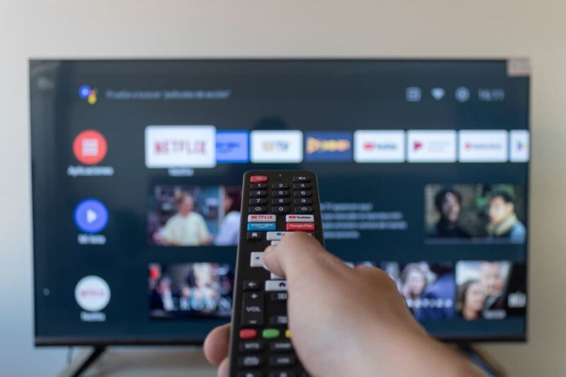homme change de chaîne sur sa TV